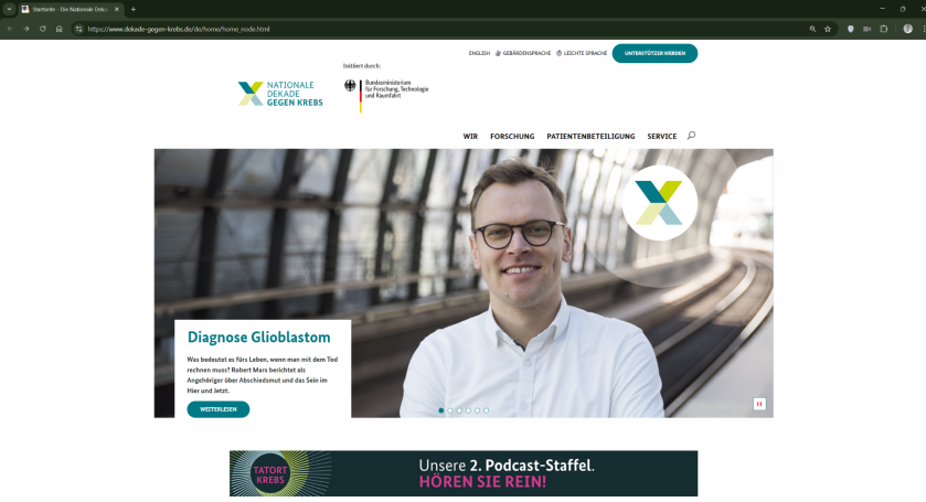 Porträt eines Mannes in einem hellen Hemd, lächelnd vor einem modernen Gebäude.